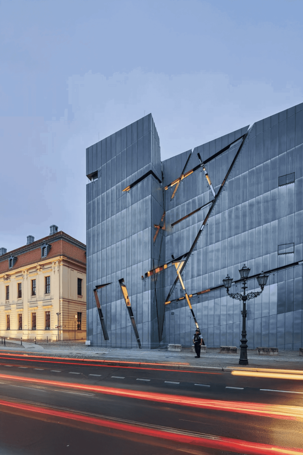 Modern glass building with architectural design and city street view.