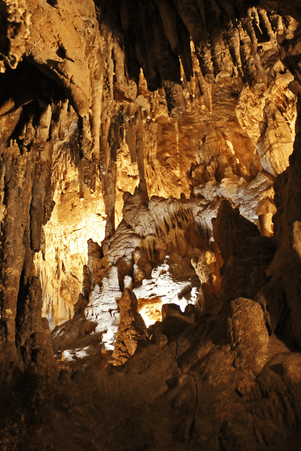 Stalactites and stalagmites formation inside a dark cave for adventure tourism.