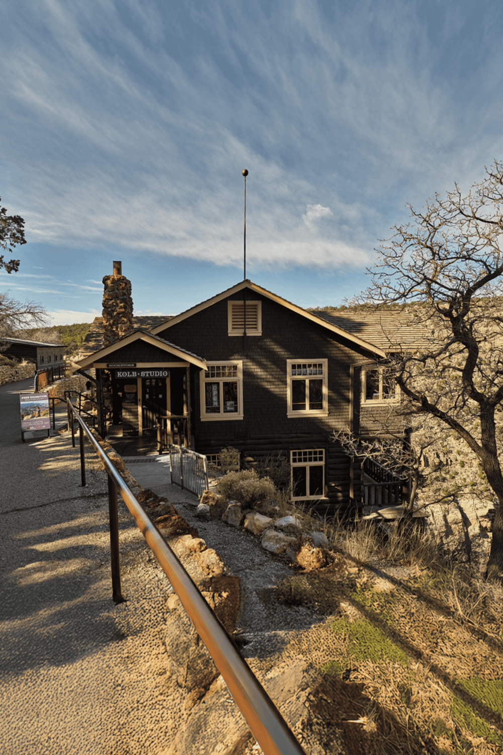 Old rustic building on scenic hillside with "KOLB STUDIO" sign, Adobe-style architecture, and surrounding desert landscape.