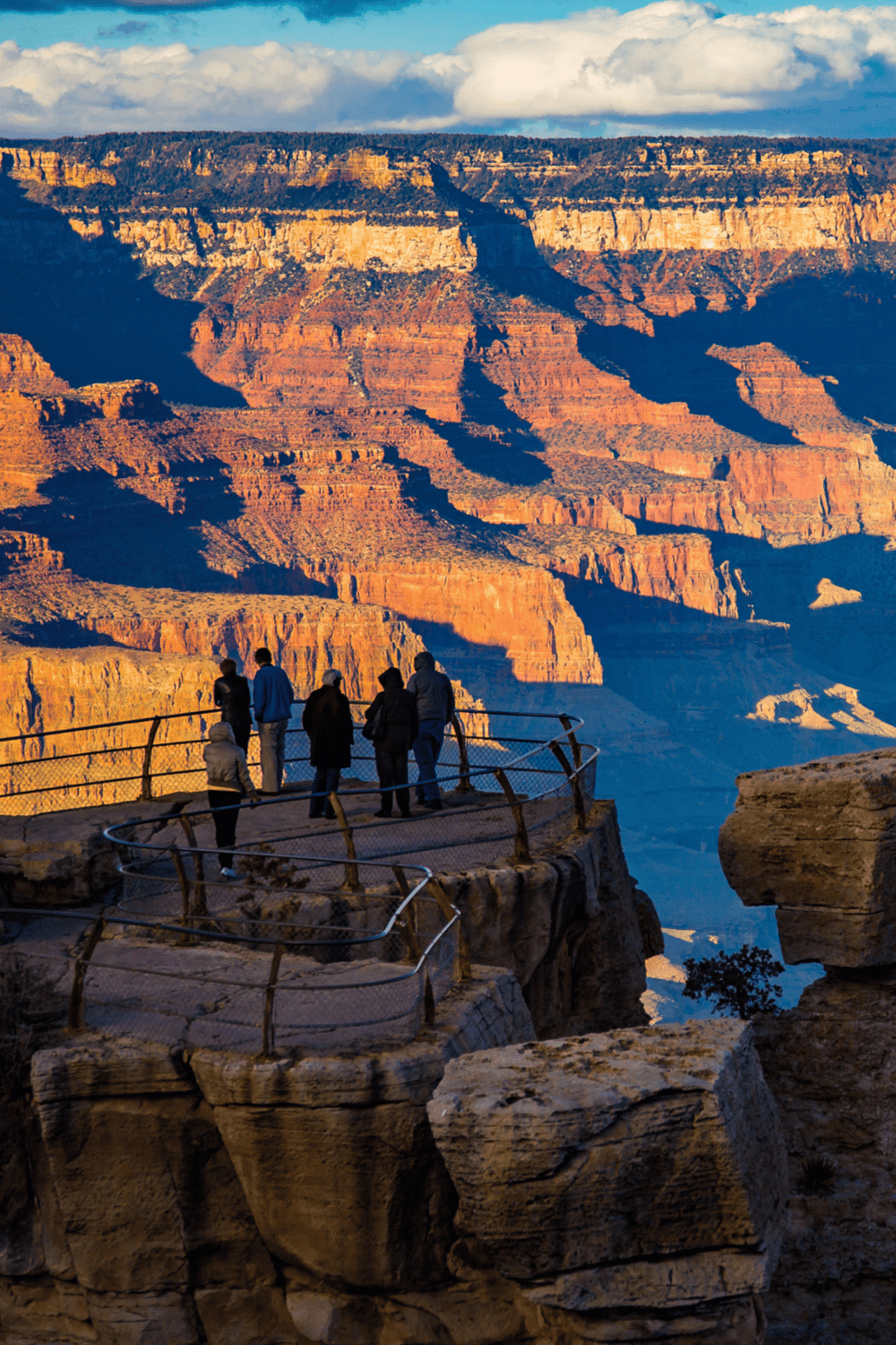 1. Grand Canyon viewpoint at sunset with visitors enjoying stunning desert landscape.