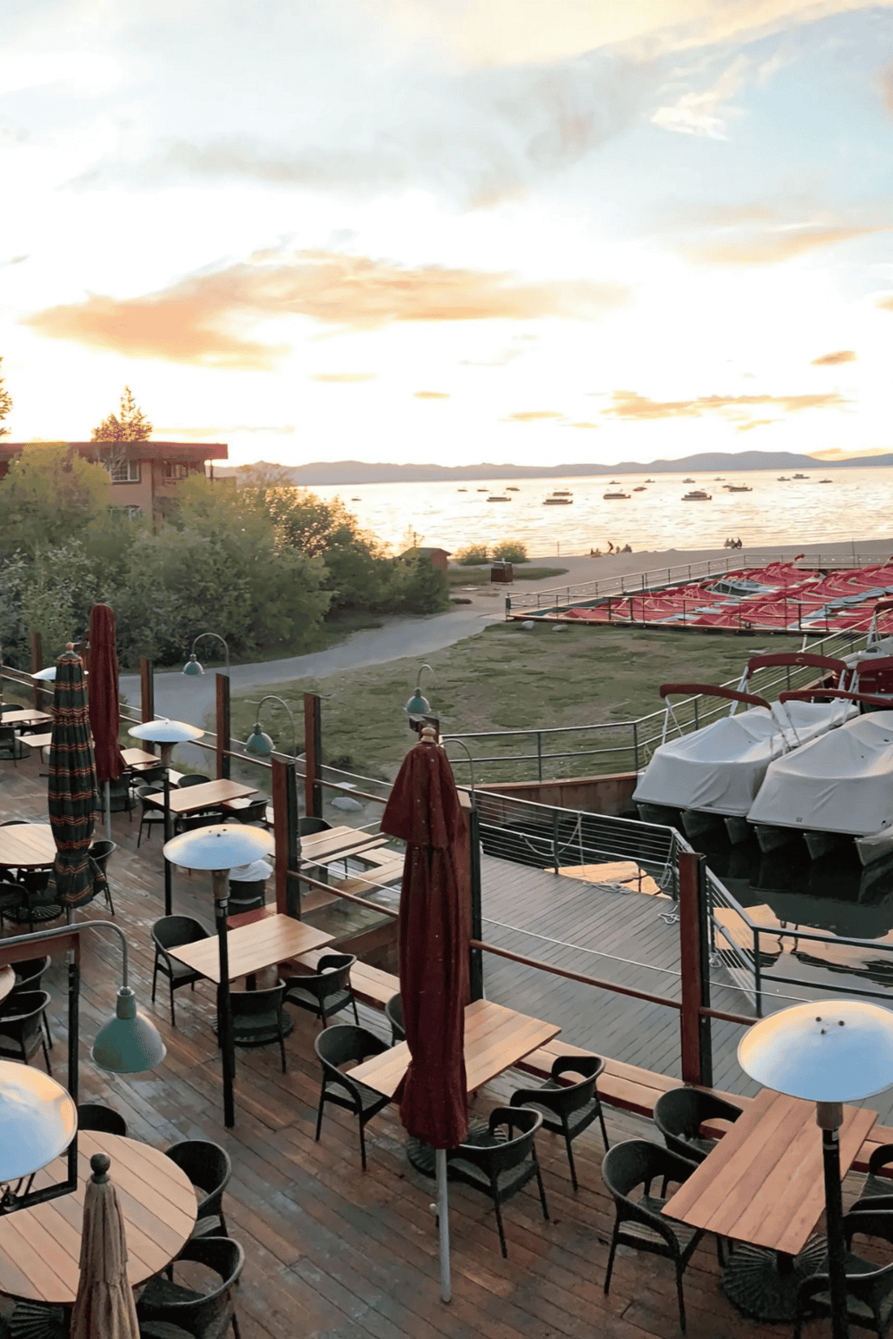 1. Waterfront restaurant seating with views of boats and sunset at Lake Tahoe.