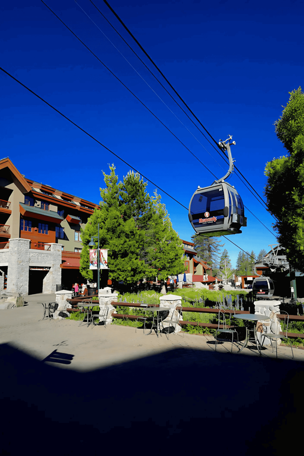 Modern mountain resort with gondola lifts, colorful buildings, and outdoor seating, perfect for adventure and relaxation.
