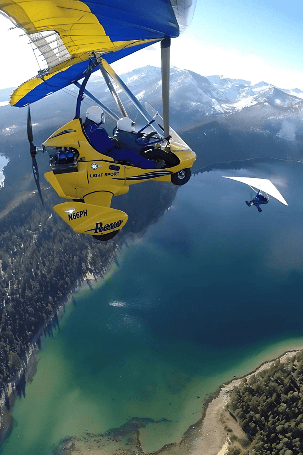 Airplane glider flying over mountain lake in clear blue skies.