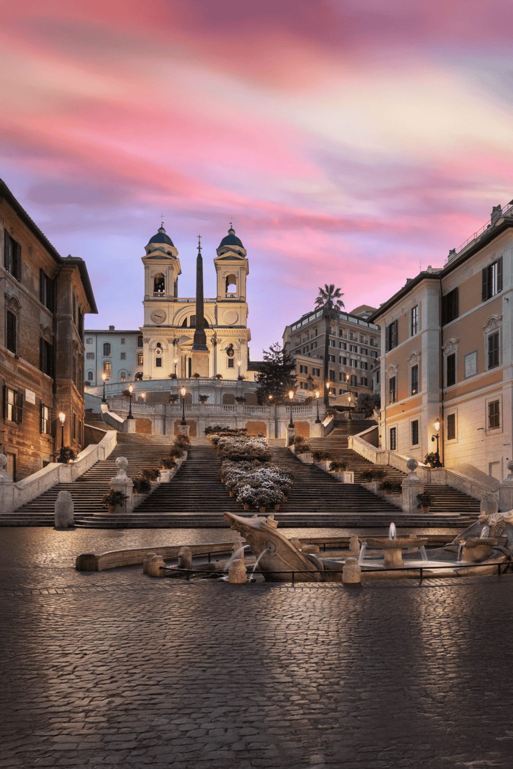 St. Patrick's Church and Spanish Steps in Rome at sunset, beautiful historic architecture, vibrant sky, popular travel destination.