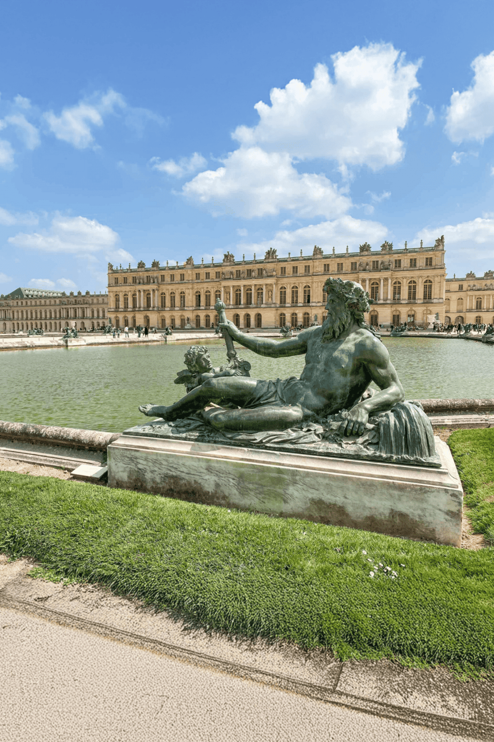 Ancient sculpture of Neptune at Palace of Versailles, France, scenic view with historic architecture.