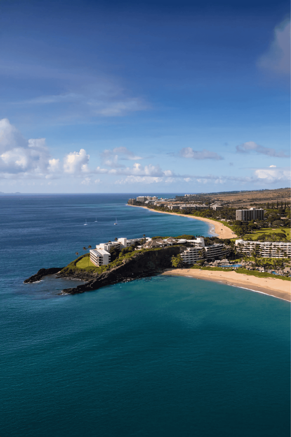 Panoramic view of oceanfront resort with sandy beaches and clear blue waters in a tropical destination.