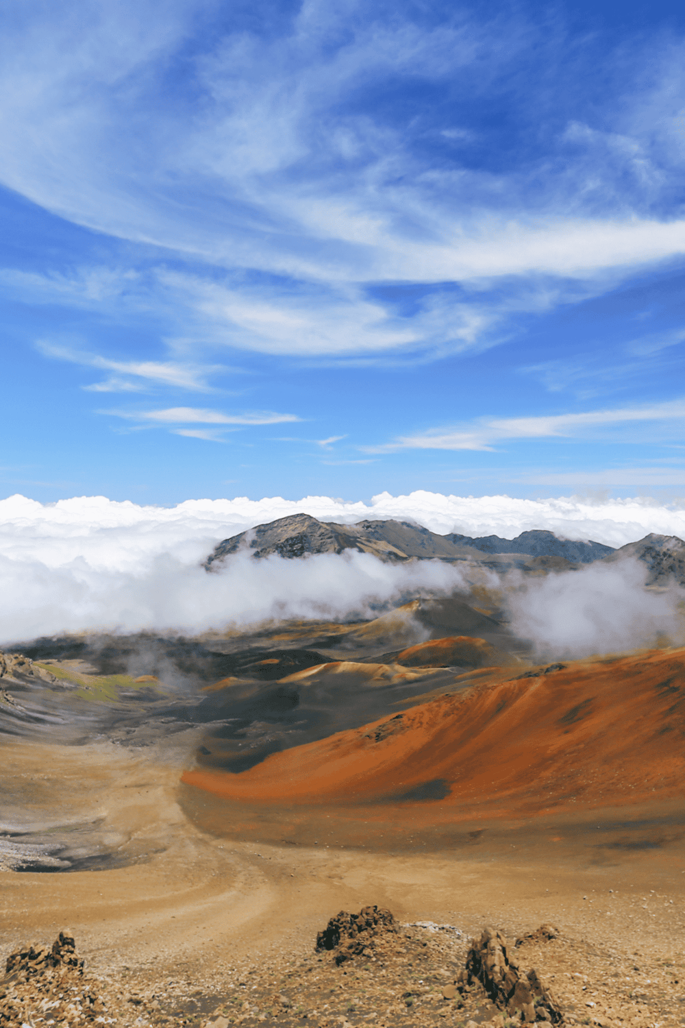 Vast mountain landscape with colorful terrain and dramatic cloud formations, perfect for adventure travel inspiration.