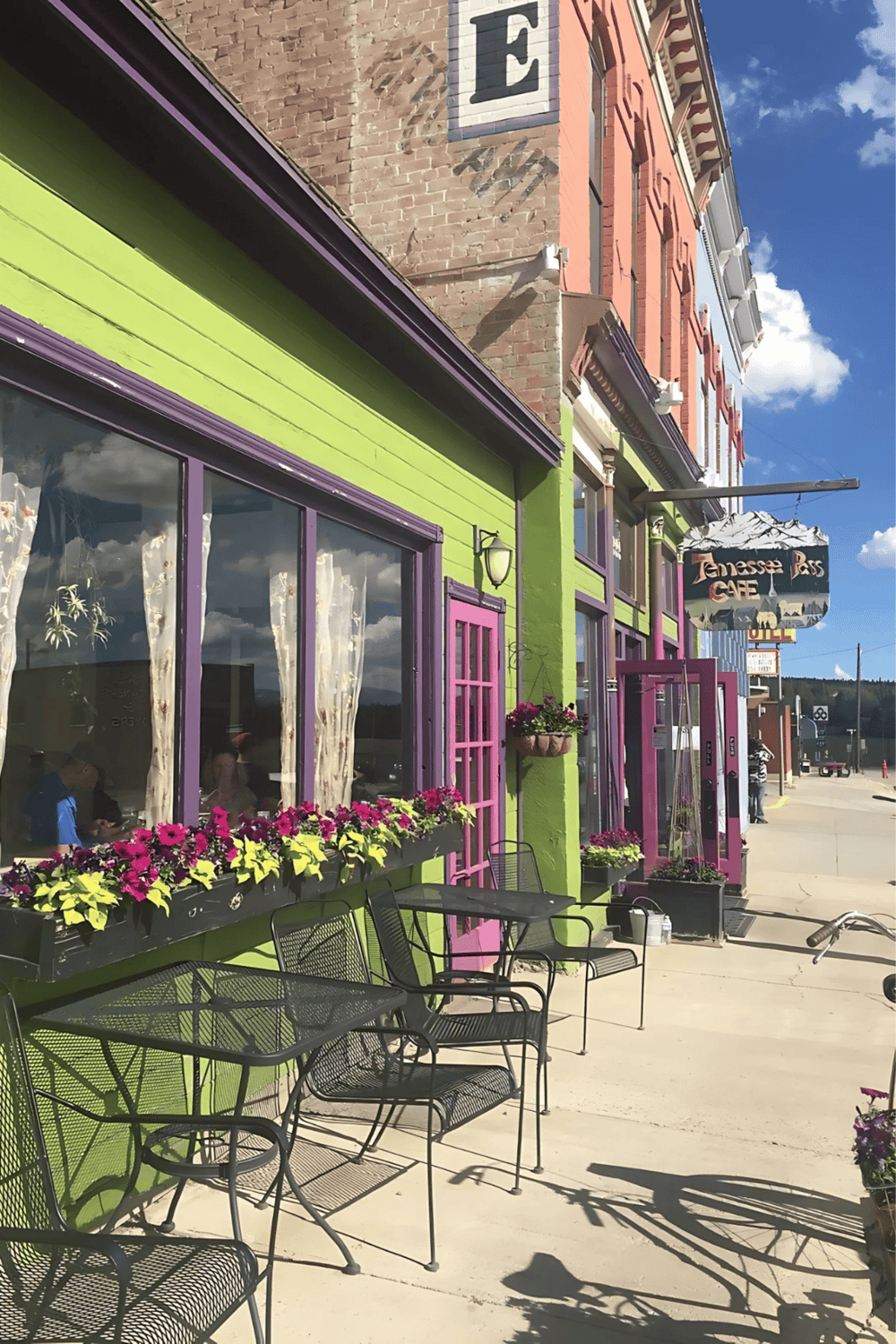 - Colorful storefront exterior of Tennessee Pass Cafe with outdoor seating and vibrant flowers.