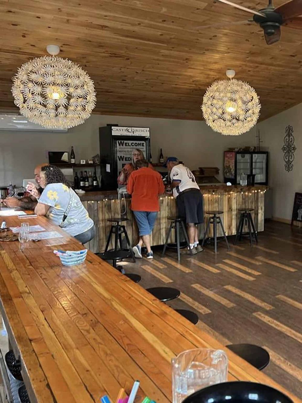 Cozy rustic restaurant interior with wood accents, unique lighting fixtures, and a welcoming bar area.