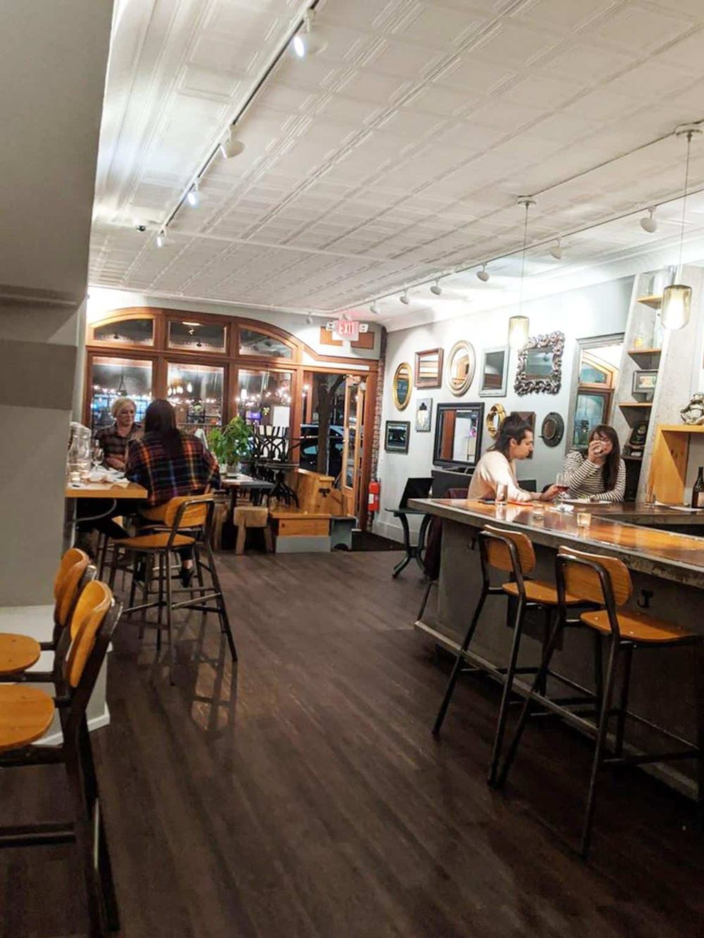 Cozy modern restaurant interior with warm lighting, stylish wall decor, and inviting seating areas for dining and socializing.