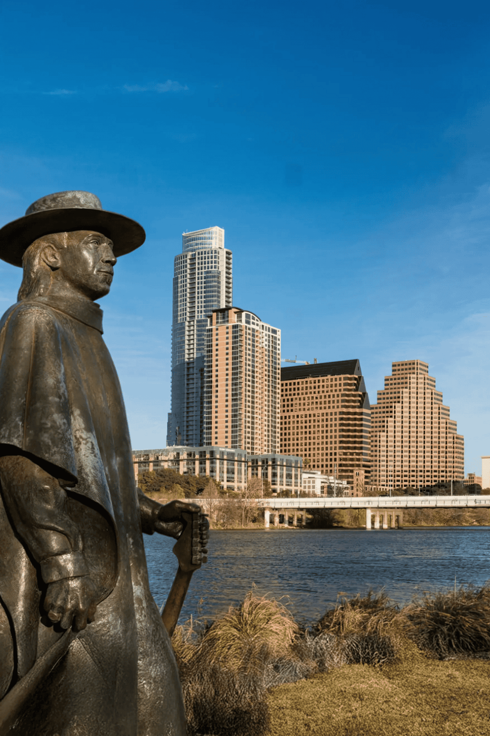 Bronze statue of explorer with city skyline in background in Austin Texas for QuestForDirections SEO images.