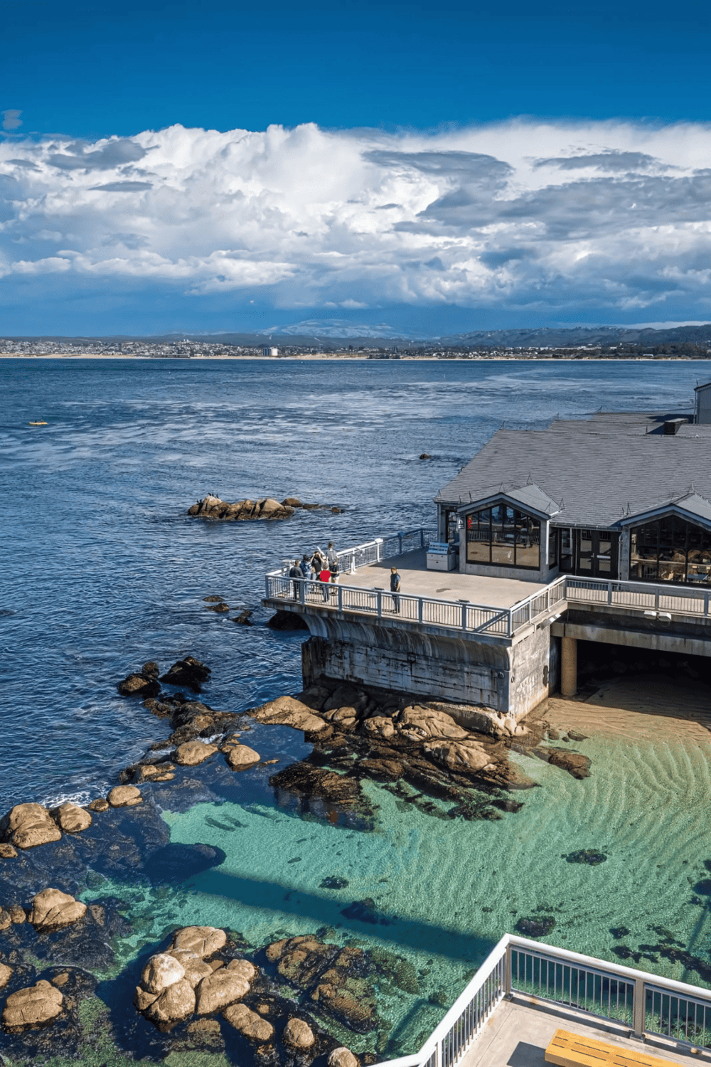 Vibrant coastal view with pier, rocky shoreline, and scenic oceanfront, perfect for travel and outdoor adventure.