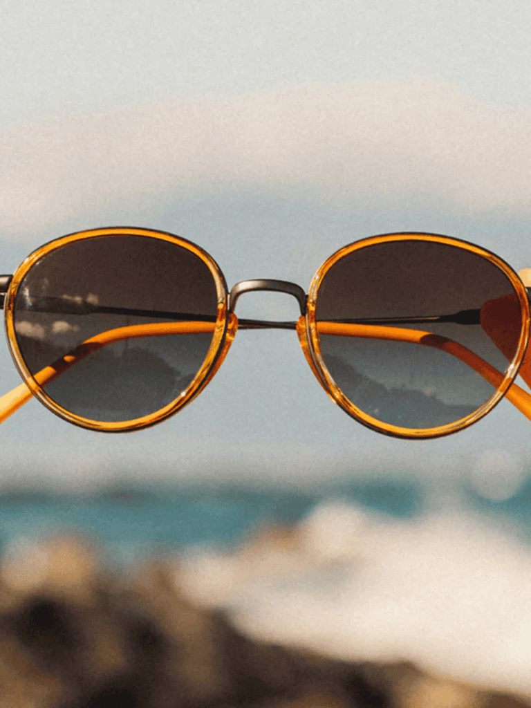 Sunglasses with ocean view background for travel and outdoor adventure SEO optimization.