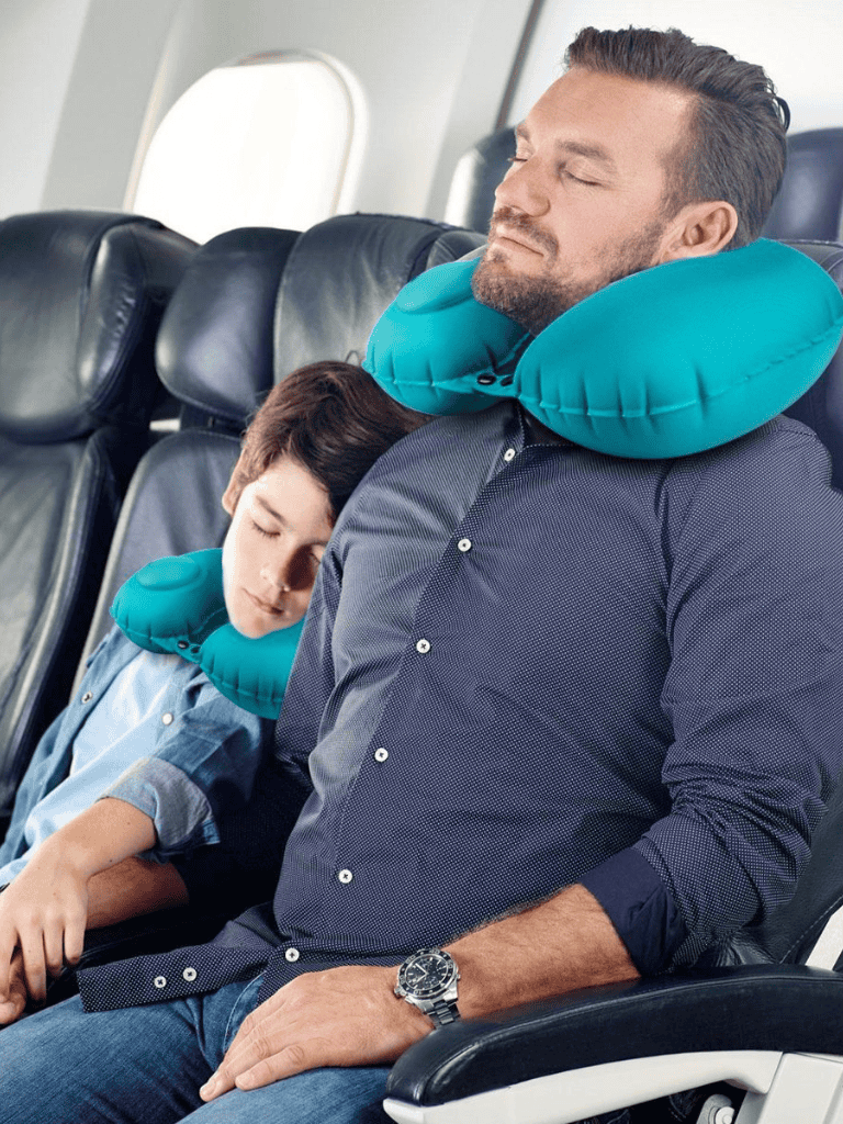 Travelers with neck pillows sleeping during flight for comfort and relaxation.