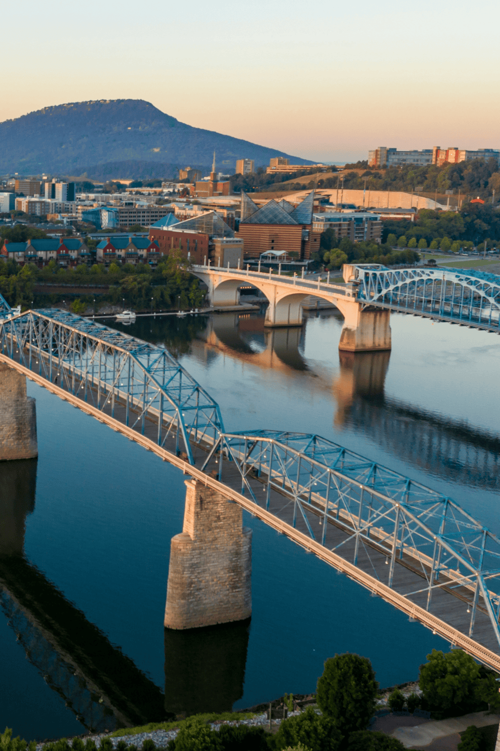 Bridge over Tennessee River with Knoxville skyline and mountains, scenic view in Tennessee.