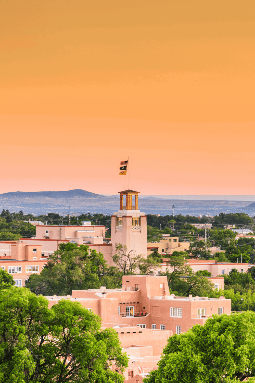 Colorful sunset over Santa Fe with adobe architecture and New Mexico landscape.