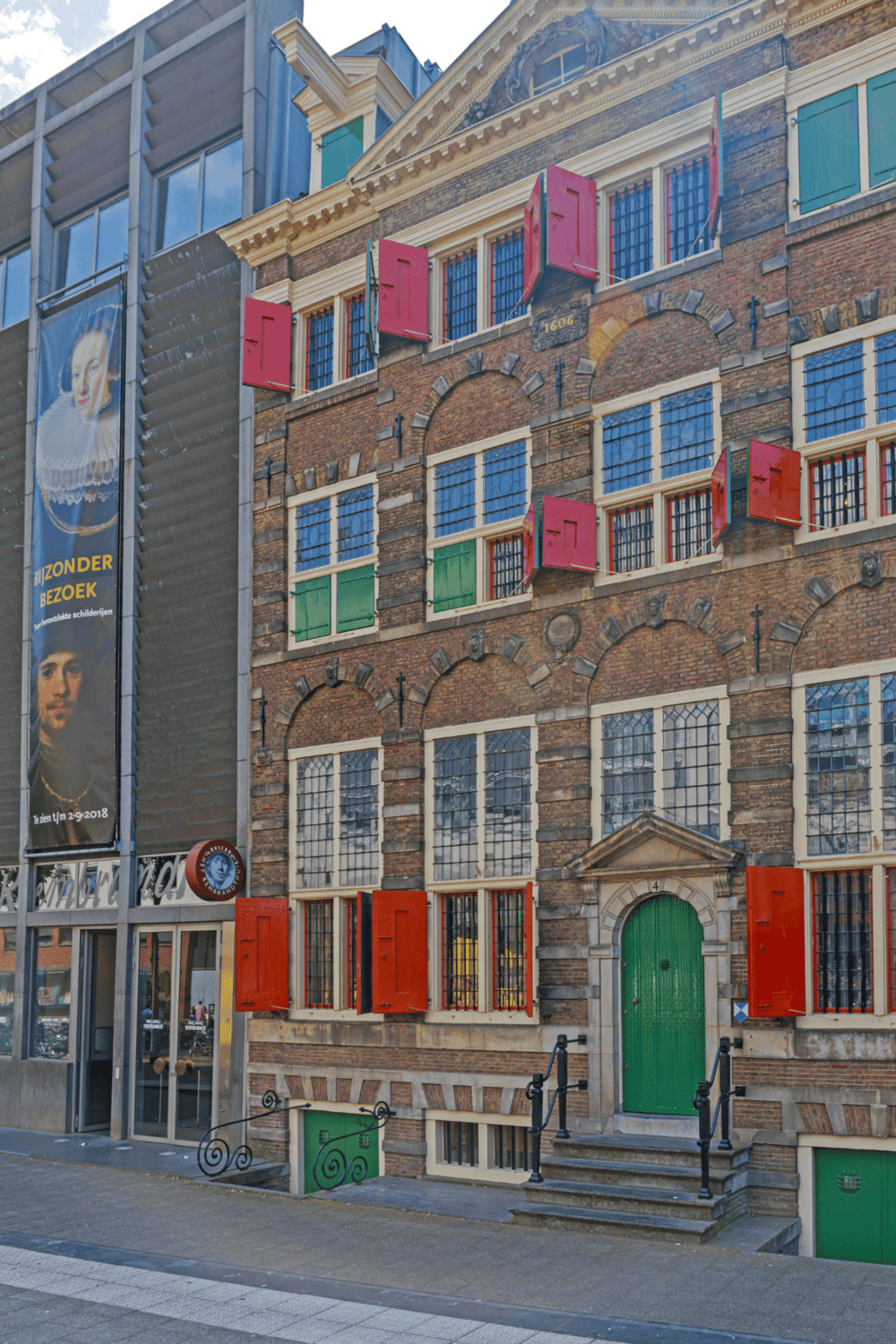 Colorful historic building with open window shutters, located in Amsterdam, Netherlands.
