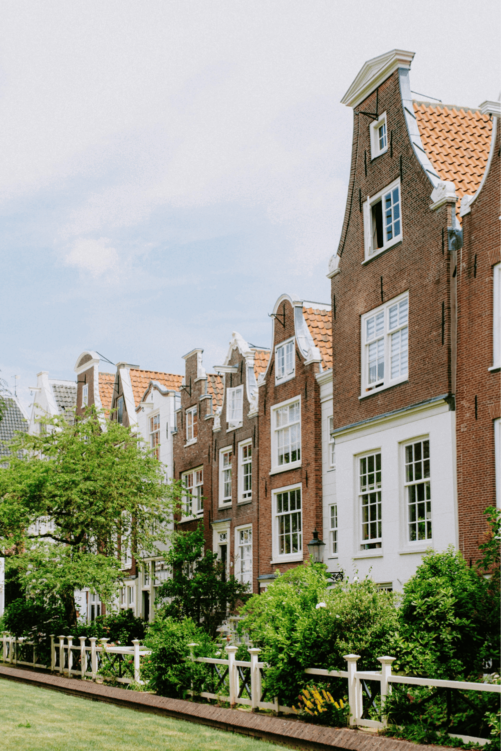 Charming Dutch-style row houses with classic brick facades and manicured gardens, perfect for real estate and neighborhood exploration.