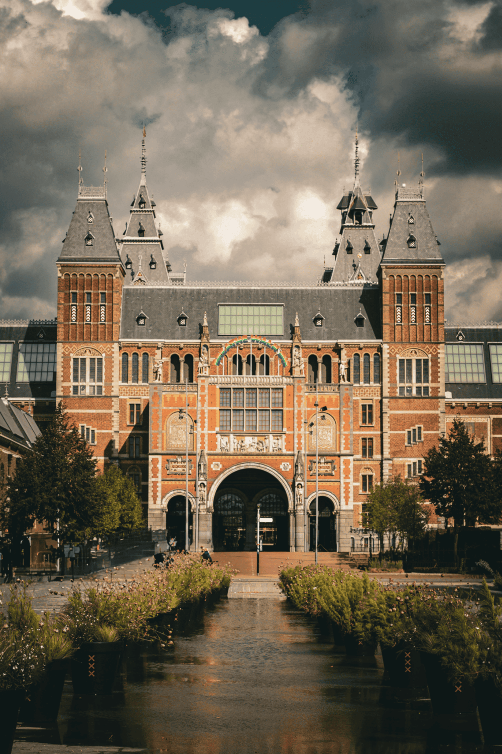 1. Historic castle with gothic architecture and spires under dramatic cloudy sky.