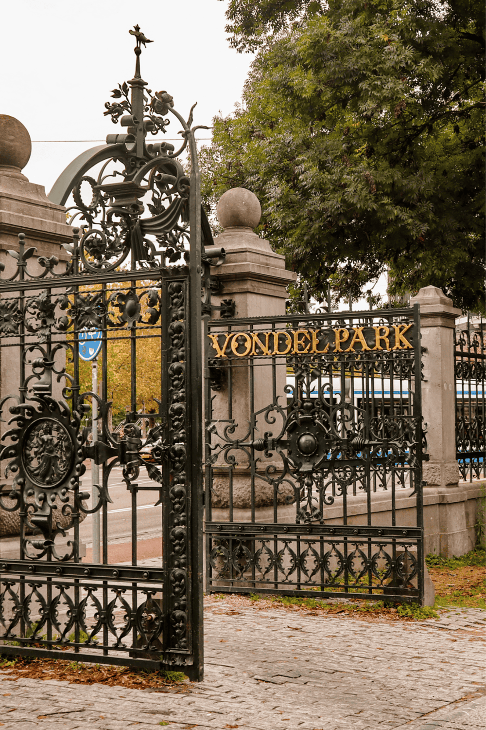 Vondel Park entrance gate, Amsterdam, Netherlands, lush green trees, historic wrought iron gates, popular outdoor recreation area.