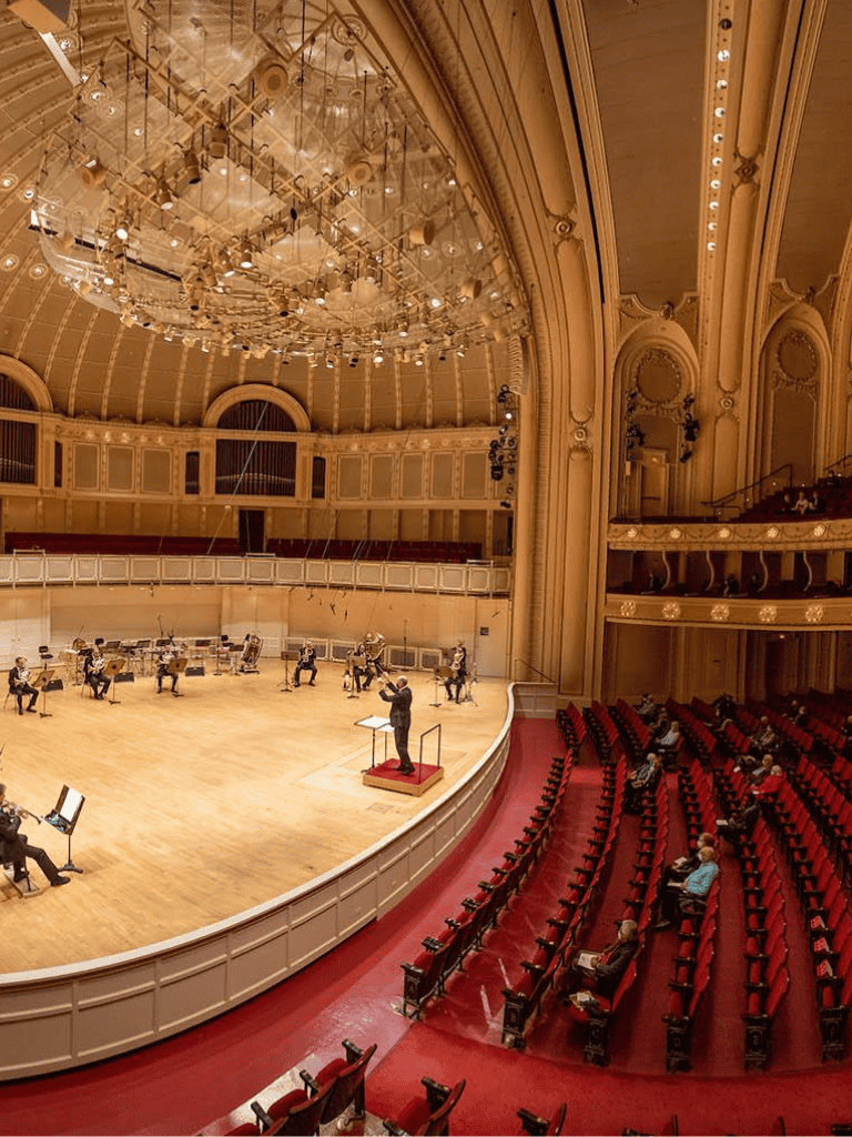 Elegant concert hall interior with orchestra and audience, showcasing world-class acoustics and stunning architecture.