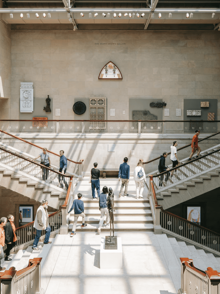 Vibrant museum interior showcasing visitors exploring historic art and exhibits at The Henry Crown Gallery.