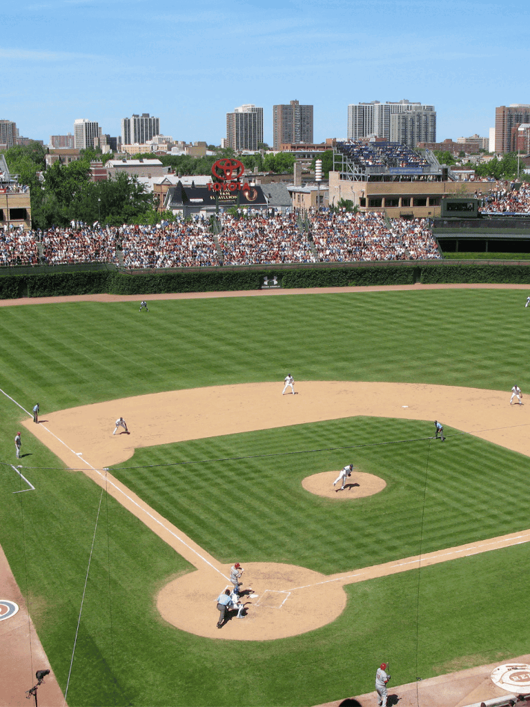 1. Baseball game at outdoor stadium with city skyline in background.