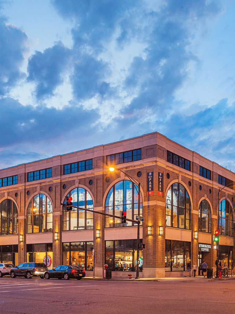 Vibrant cityscape with a modern, multi-story Starbucks Coffee store at dusk, vibrant skies and urban scene.
