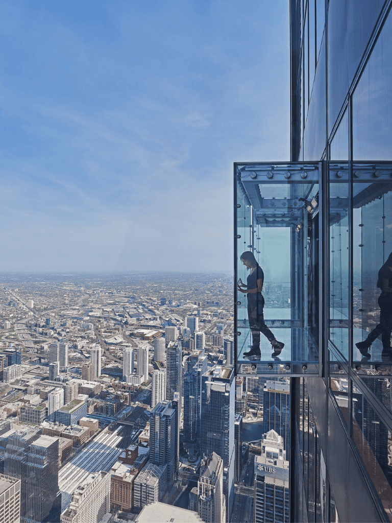Thrilling glass skywalk on skyscraper offering panoramic city views, adventure, and sightseeing in urban landscapes.
