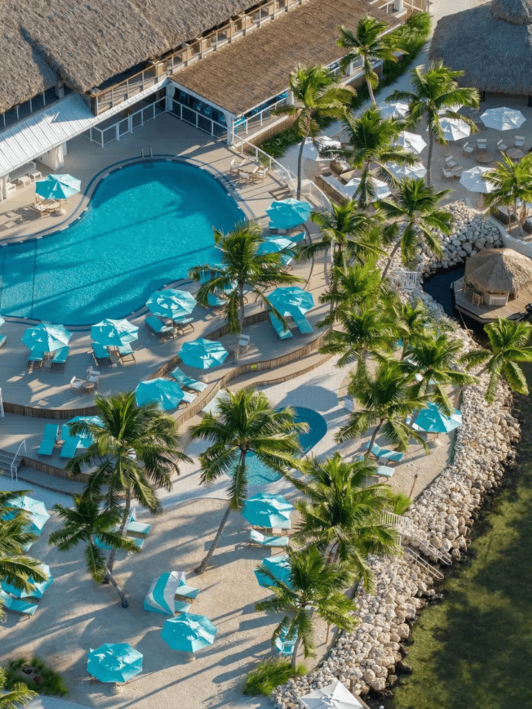 Luxurious tropical resort with shimmering pool and palm trees.