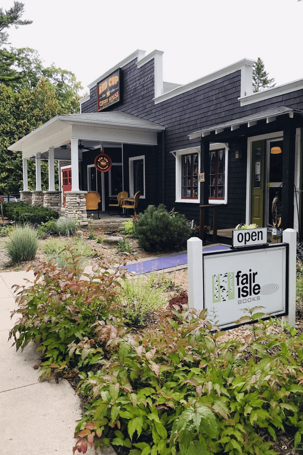 Cozy local bookstore with outdoor seating, inviting atmosphere, and vibrant garden on a sunny day.