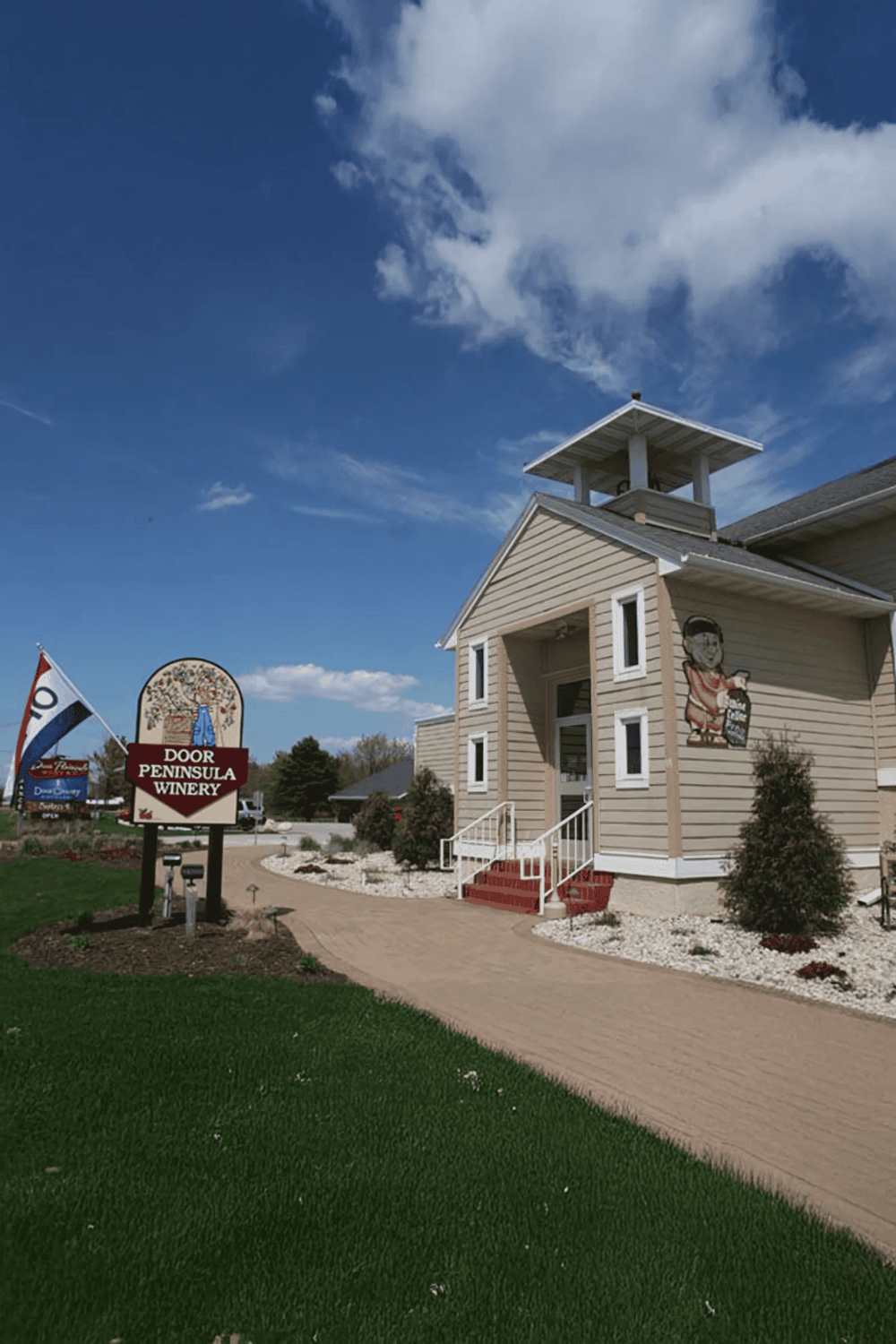 Colorful winery building with a "Door Peninsula Winery" sign on a sunny day.