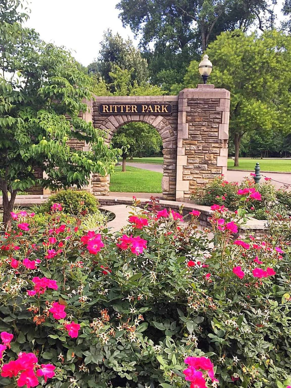 Beautiful Ritter Park entrance with vibrant pink flowers and lush greenery.