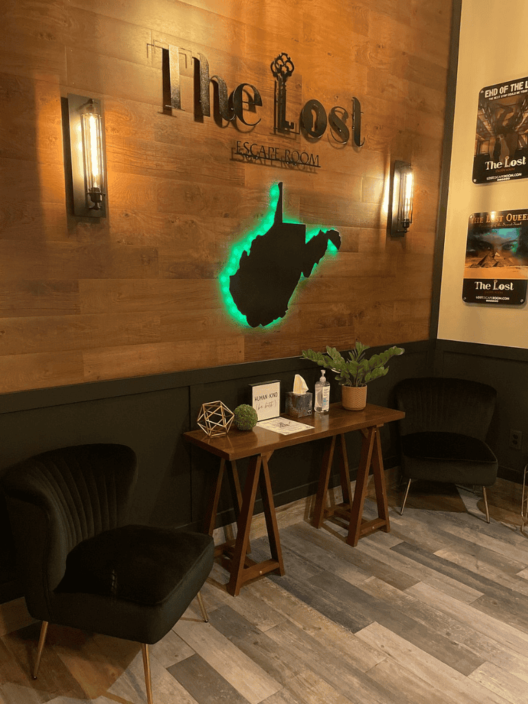 Escape room entrance with "The Lost" sign, wooden decor, and cozy seating area.