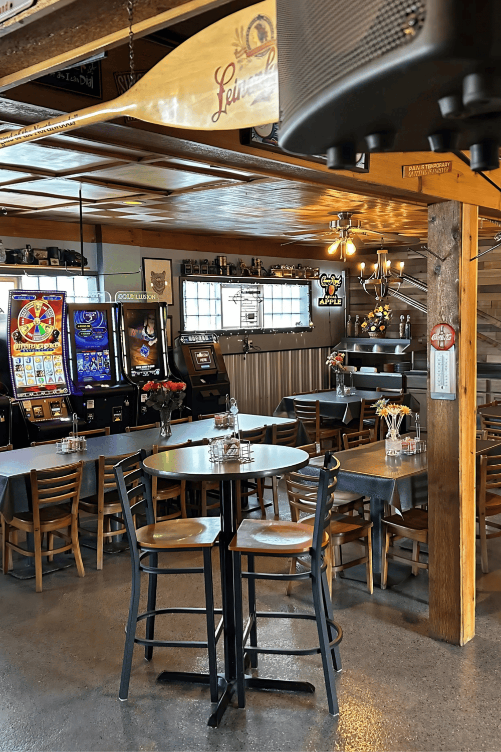 1. Cozy restaurant with slot machines, wooden accents, and casual dining atmosphere.