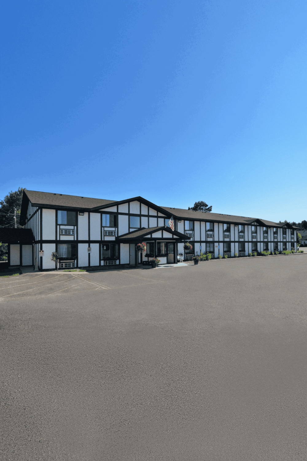 Spacious hotel exterior with parking lot, ideal for travel and accommodations.