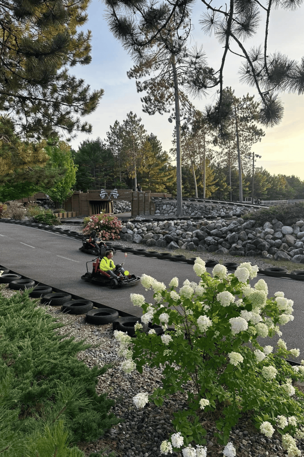 Kids go-kart racing at QuestForDirections indoor go-kart track in a scenic outdoor setting.