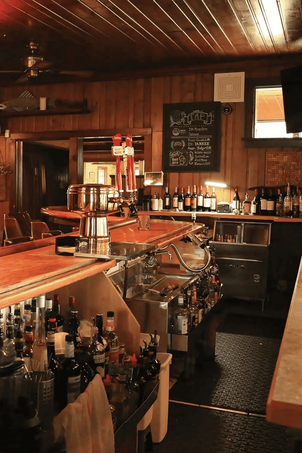 Cozy rustic bar interior with craft beer taps and liquor bottles, perfect for a welcoming pub experience.