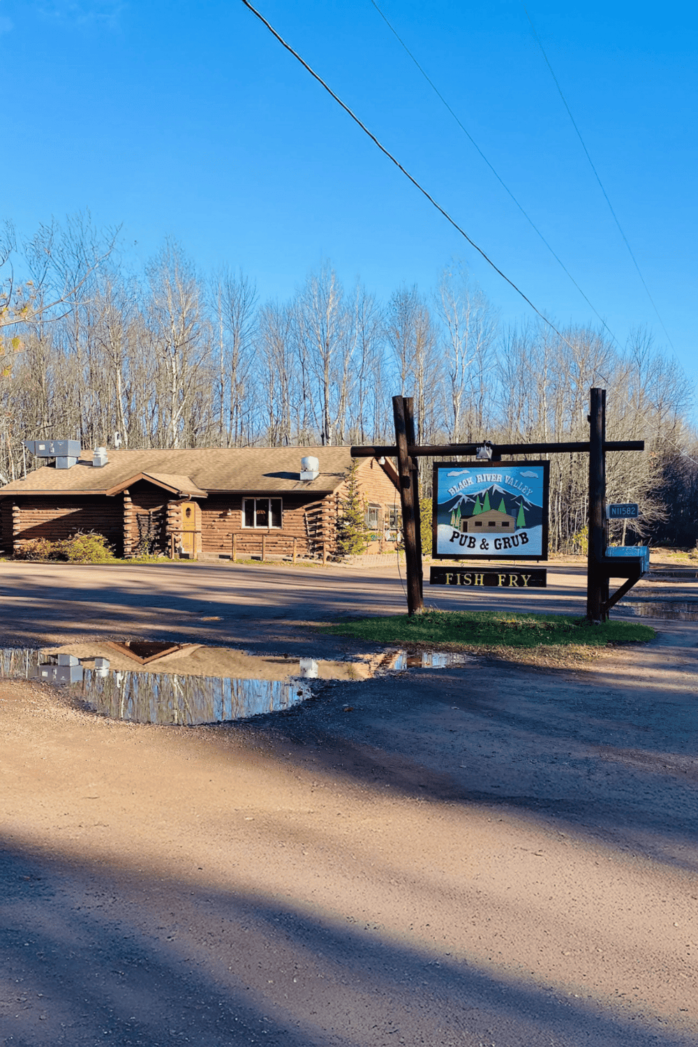 Cozy log cabin restaurant near scenic trees and river reflections, perfect for dining in nature.