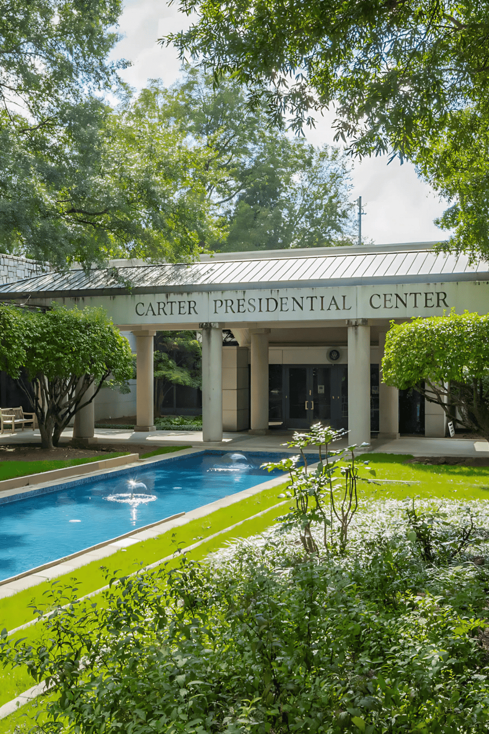 Historic Carter Presidential Center entrance with lush greenery and fountain, a renowned landmark for political history tours.