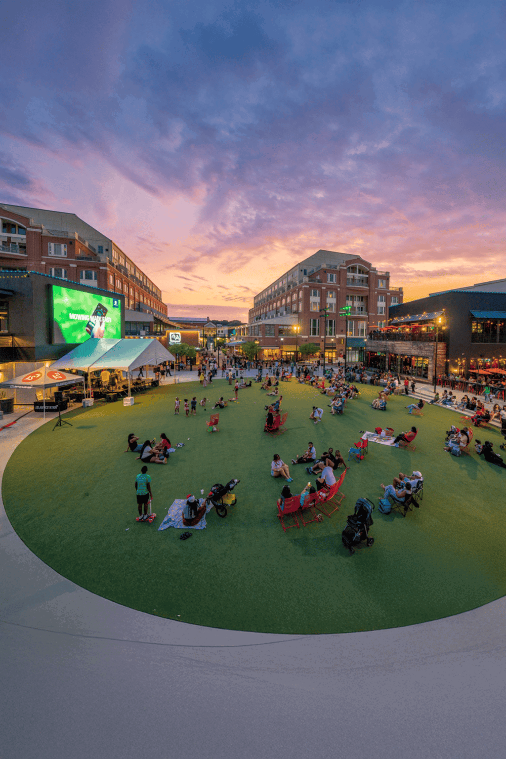 Relaxing evening at a vibrant shopping and entertainment district with outdoor seating and a lively crowd.
