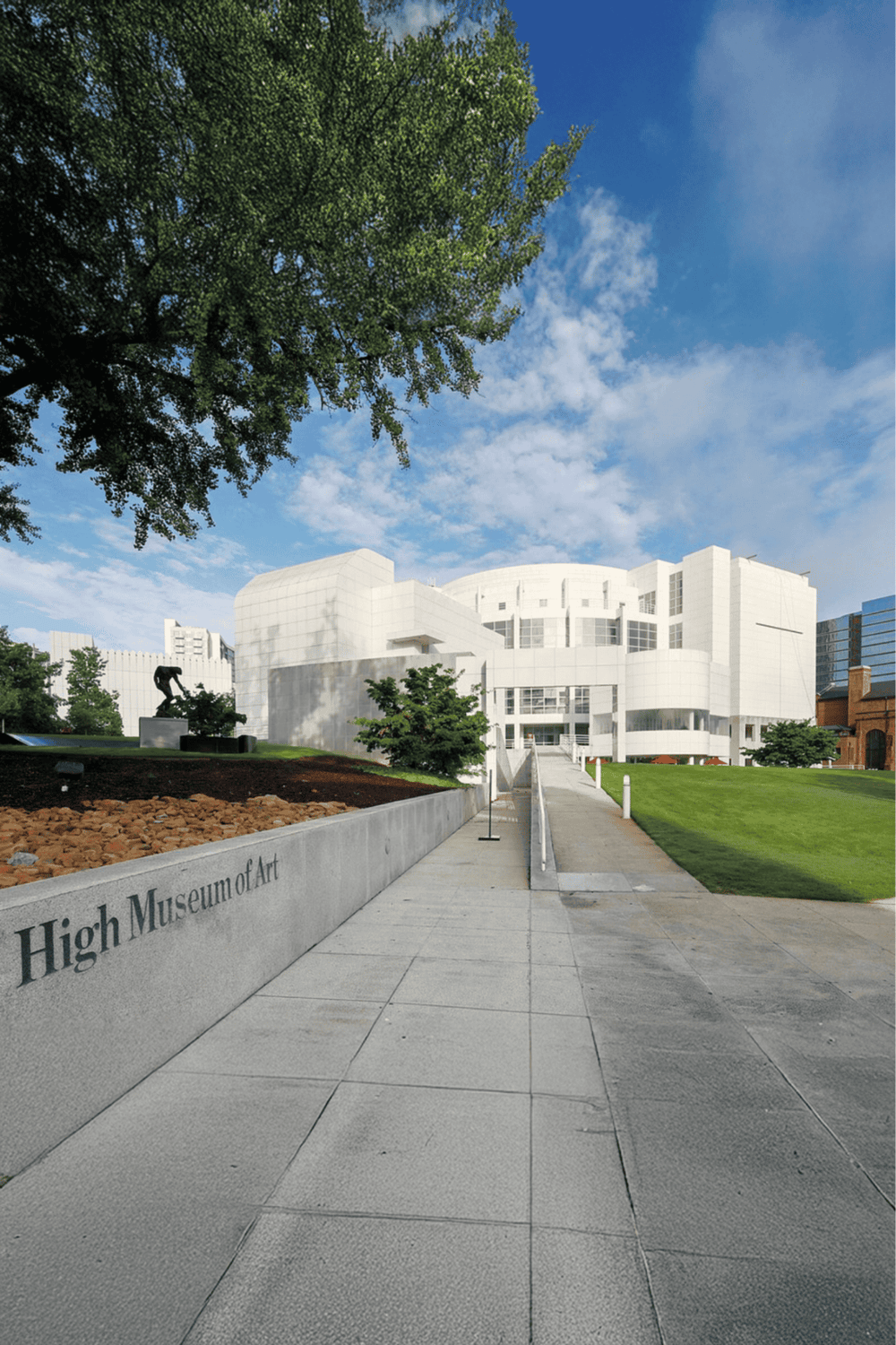 Modern art museum exterior with pathway and lush greenery, showcasing art, architecture, and cultural exploration.