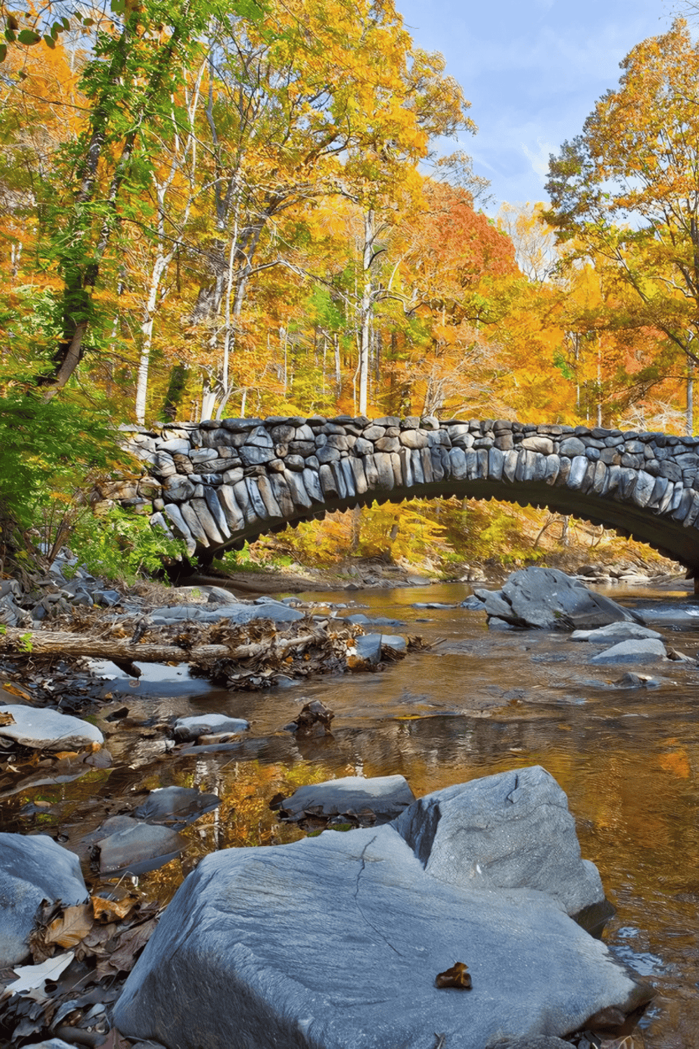 1. Autumn river with stone bridge and colorful fall foliage in the background.