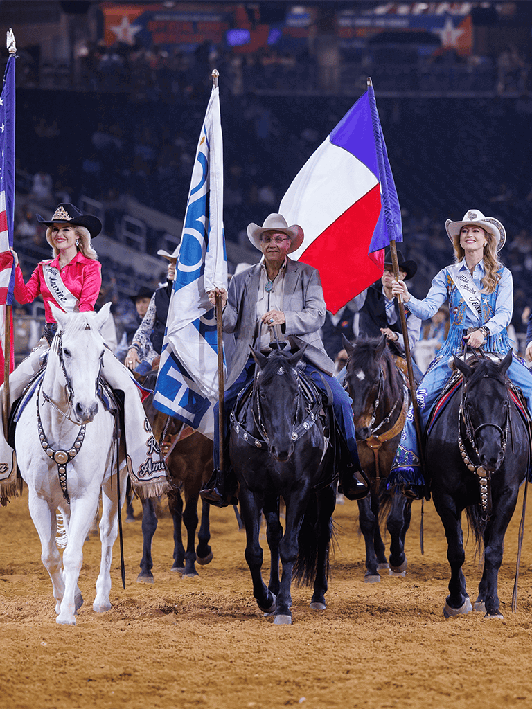 Rodeo parade with riders holding flags, showcasing western culture and traditions at a rodeo event.