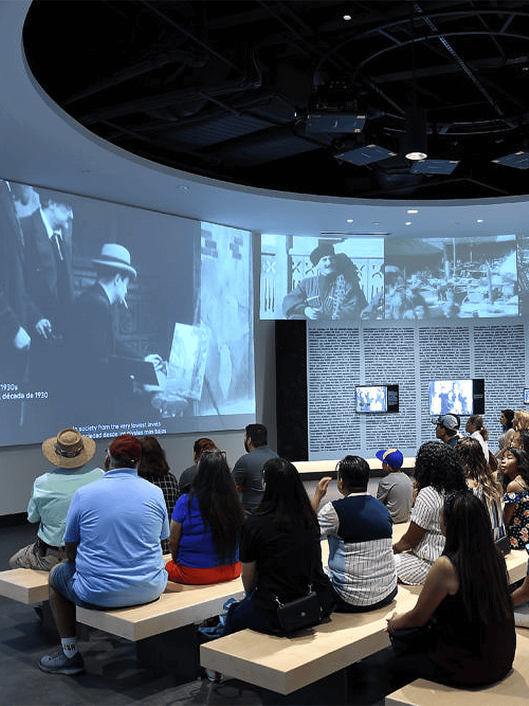 Historic black-and-white film screening at QuestForDirections museum exhibit.