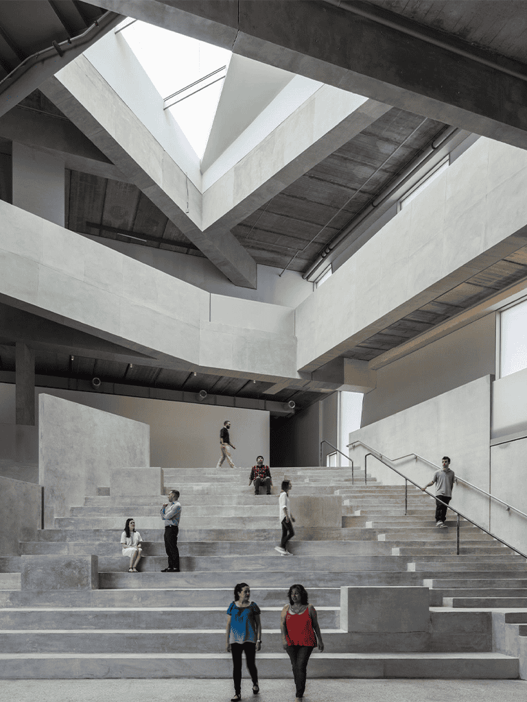 1. Modern concrete interior with large staircase and natural skylight lighting.