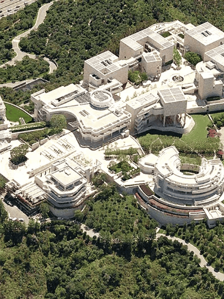 Modern architectural complex nestled within lush green landscape, designed with clean lines and innovative structures.