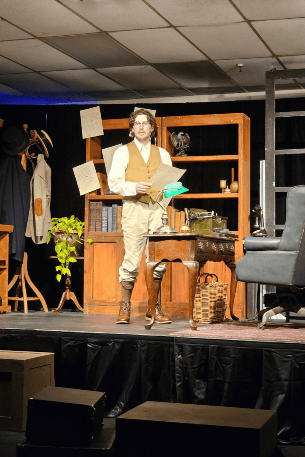 1. Vintage office scene with actor reading script, wooden furniture, and classic decor, theater set.