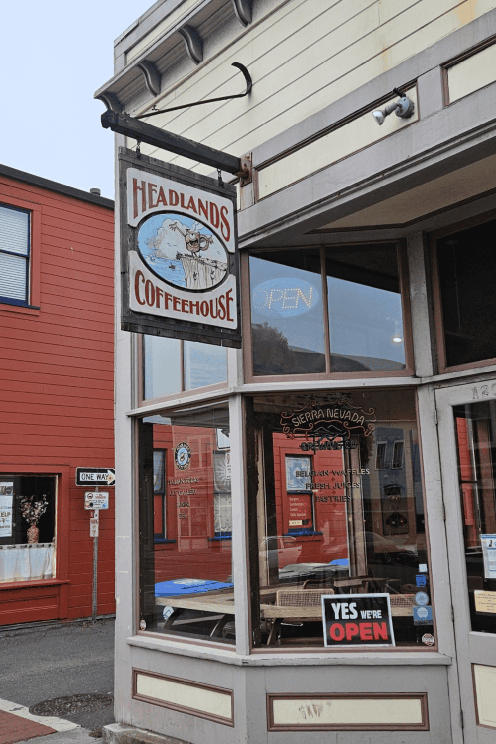 Cozy coffeehouse sign at Headlands Coffeehouse with outdoor seating and local art ambiance.