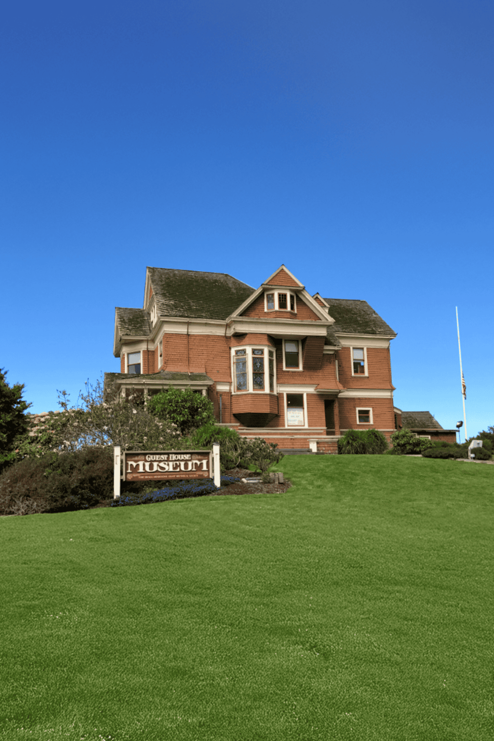 Victorian guest house museum with historic architecture and lush green lawn in scenic setting.